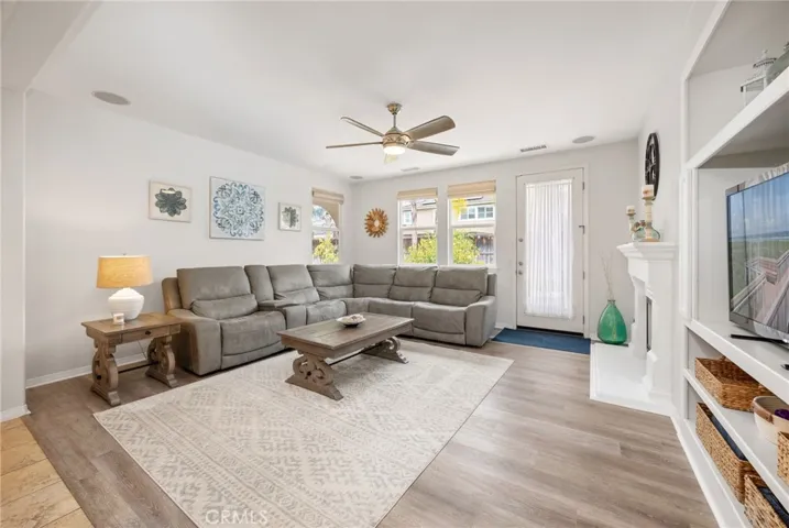 Family Room with built-in Speakers, Entertainment Center, custom White Mantel & Fireplace and Backyard access