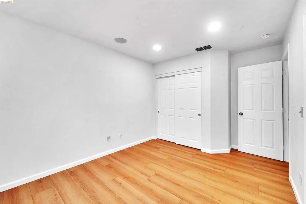 Light wood-finish flooring complemented by white baseboards