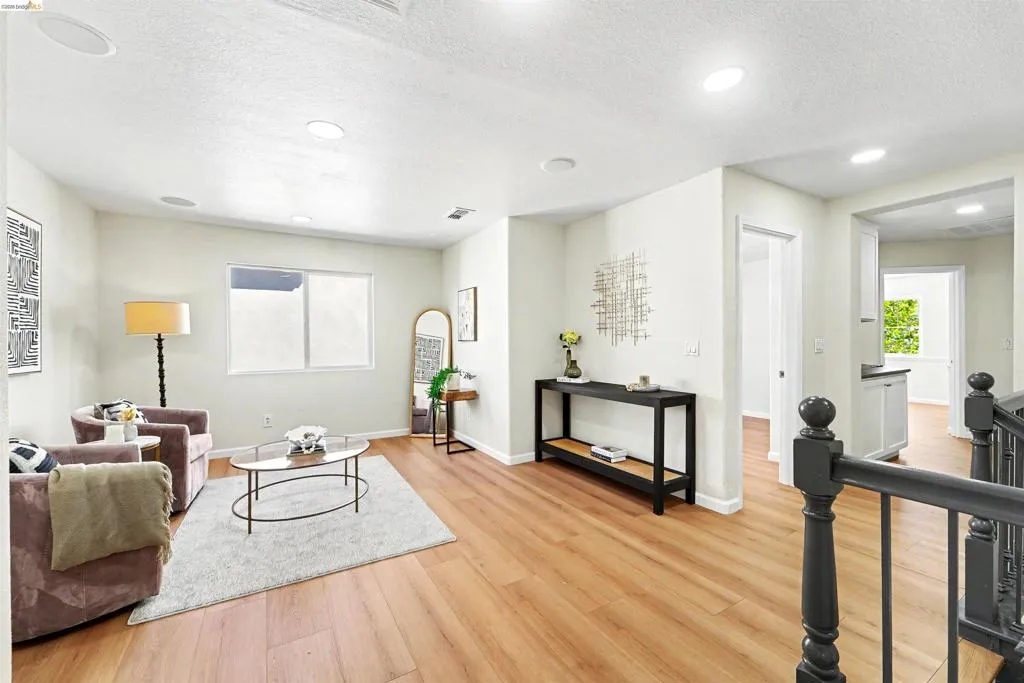 Bright living area featuring wood-finish flooring, recessed lighting, and a neutral color palette