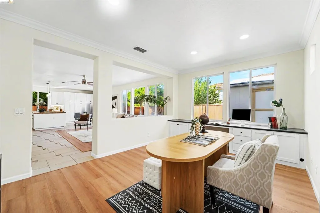 Bright room featuring wood-finish flooring, recessed lighting, and crown molding
