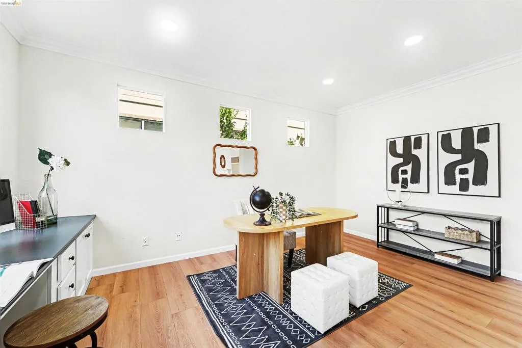 Bright interior space featuring wood-finish flooring and multiple windows