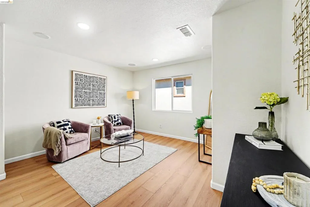 Bright living area featuring wood-finish flooring, recessed lighting, and a large window