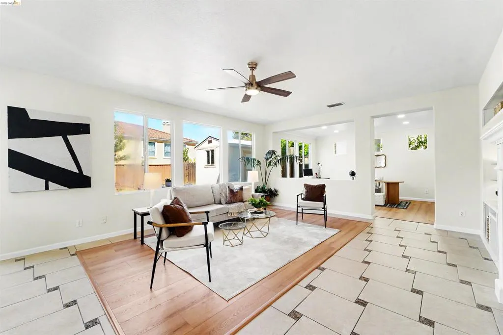Bright living area featuring wood-finish flooring and a ceiling fan