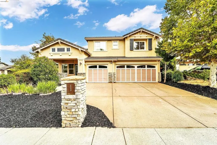 Two-story residence featuring a stucco exterior with stone accents and a covered entry