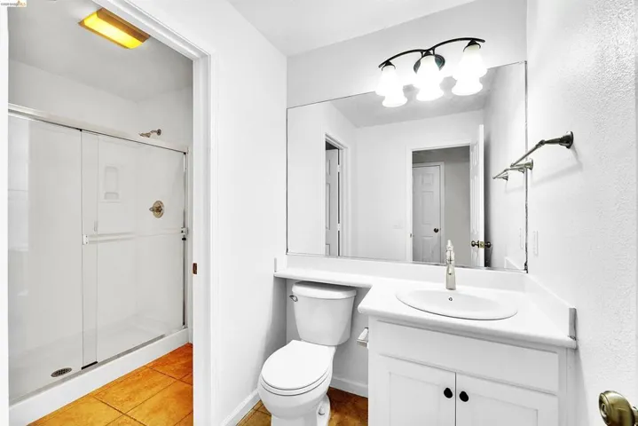 Bathroom featuring a white vanity with an integrated sink, brushed nickel faucet, and under-cabinet storage