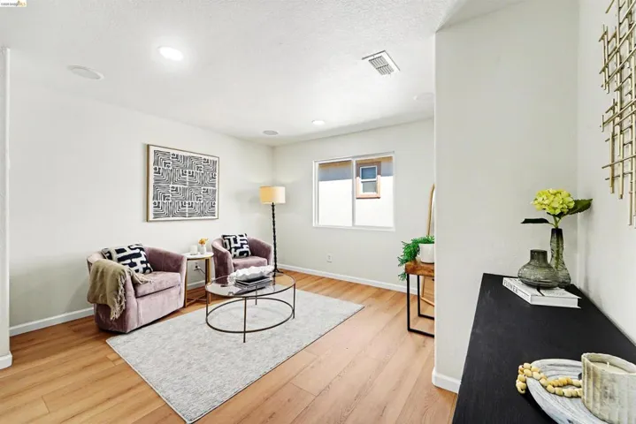 Bright living area featuring wood-finish flooring, recessed lighting, and a large window