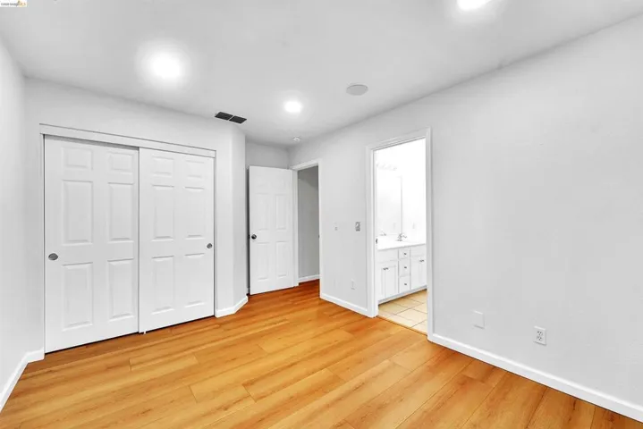 Spacious room featuring wood-finish flooring and recessed lighting