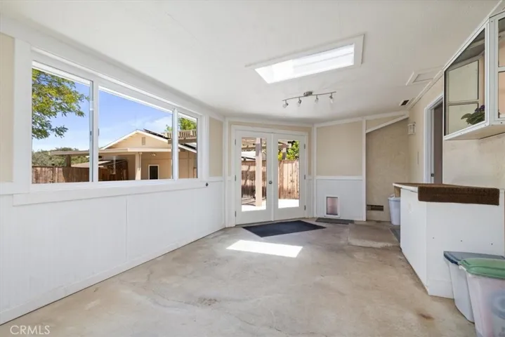 So much potential in this enclosed sunroom with french doors to back yard.