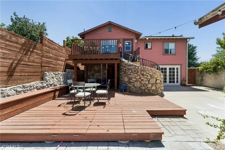 Backyard area featuring a spacious raised deck and a covered patio for outdoor entertaining.