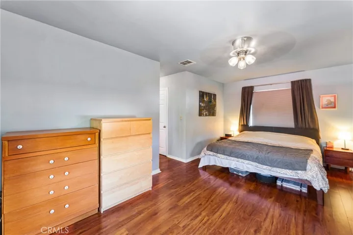 Large primary bedroom featuring a spacious sitting and television area.