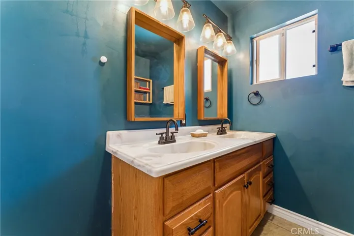 Primary bathroom featuring a dual vanity sink and a combination shower/tub