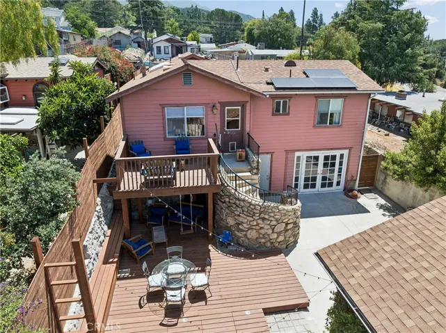 Elevated view of the balcony and decking area, featuring a stone-surround staircase leading to the double-door entry of the walk-out room.