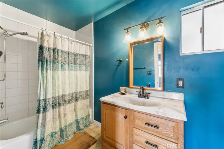 Hall bathroom featuring a vanity and a combined shower/tub