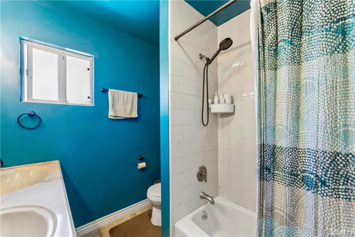 Primary bathroom featuring a dual vanity sink and a combination shower/tub.