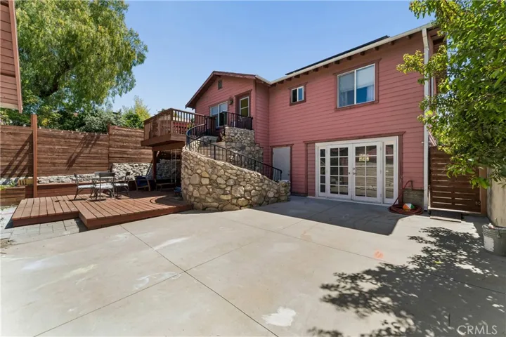 Spacious outdoor deck perfect for entertaining, elegant stone-surround staircase to lower level & grand double-door entry to walkout basement.
