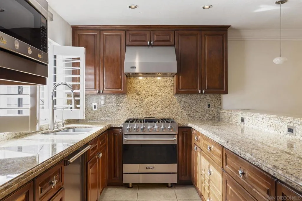 Open Floor Plan Kitchen with Kitchen Island Bar Area Dining, with Upgraded Viking Kitchen Appliances, Baseboards & Crown Moulding, and Custom Plantation Shutters.
