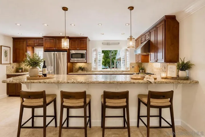 Open Floor Plan Kitchen with Kitchen Island Bar Area Dining, with Upgraded Viking Kitchen Appliances, Baseboards & Crown Moulding, and Custom Plantation Shutters. Virtually Staged.
