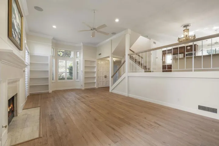 Living Room, Offering Vaulted Ceilings, Custom Plantation Shutters, Floor-Ceiling Windows & Doors, Custom Enlarged Crown Moulding & Baseboards, Wood Burning/Gas Start Fireplace, Custom Audio and Lighting in Walls & Ceiling.