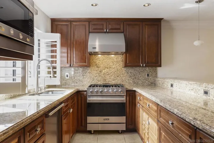 Open Floor Plan Kitchen with Kitchen Island Bar Area Dining, with Upgraded Viking Kitchen Appliances, Baseboards & Crown Moulding, and Custom Plantation Shutters.
