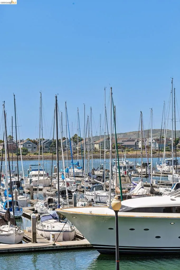Marina with numerous boats docked, featuring a large white yacht in the foreground