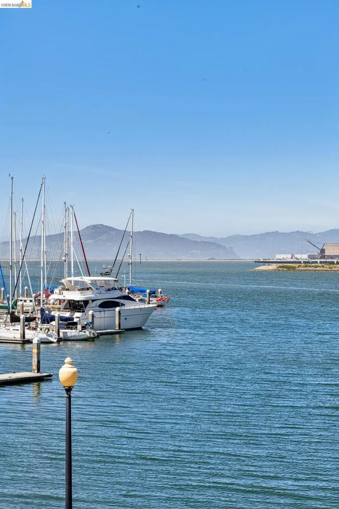Deep blue waters with moored boats and distant mountains