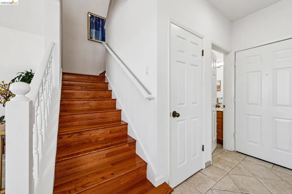 Hardwood staircase featuring white risers and a white balustrade