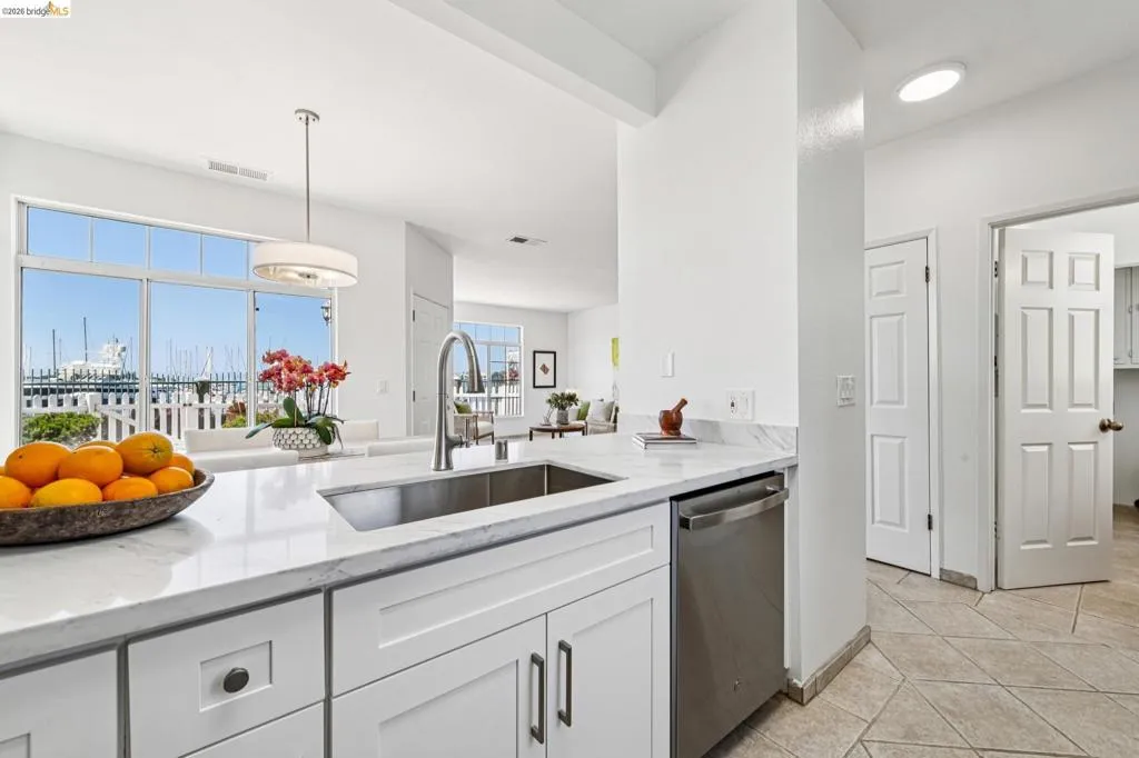 Kitchen island featuring a stainless steel undermount sink, gooseneck faucet, and integrated dishwasher
