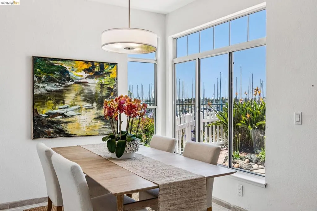 Expansive windows overlooking a marina with boats and lush landscaping