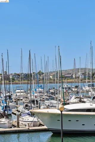 Marina with numerous boats docked, featuring a large white yacht in the foreground