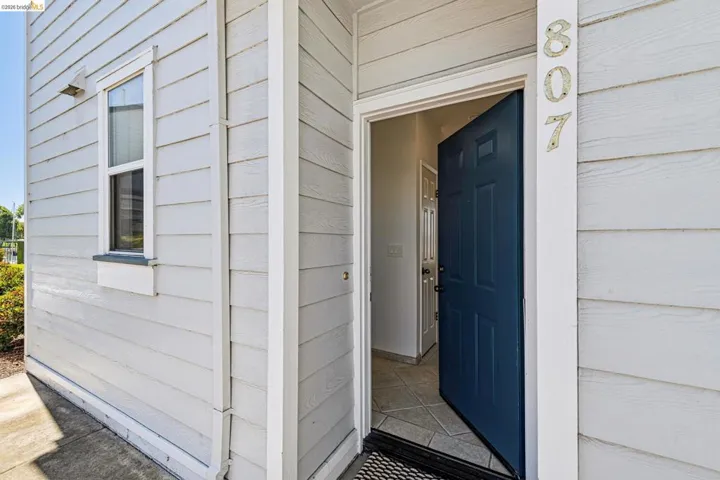 Entryway featuring a panel door, light-colored siding, and a window with a flower box