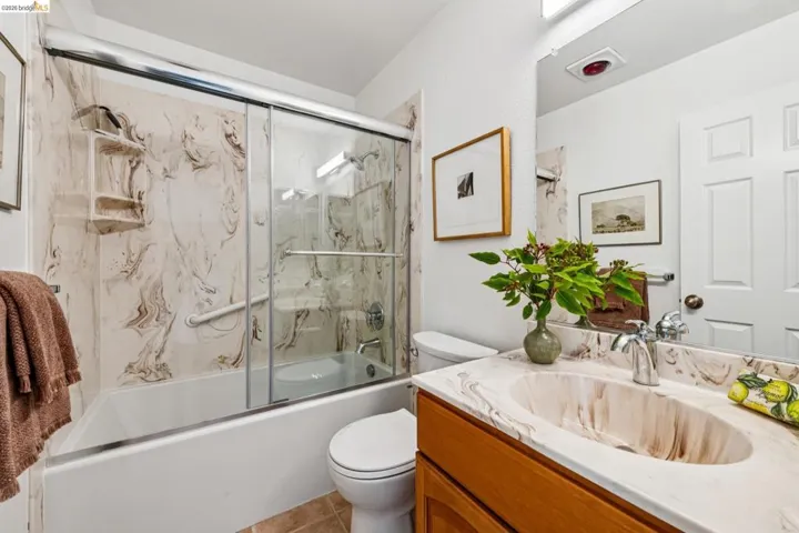 Bathroom vanity featuring an integrated sink with a marble-effect finish, a coordinating backsplash, and a chrome faucet