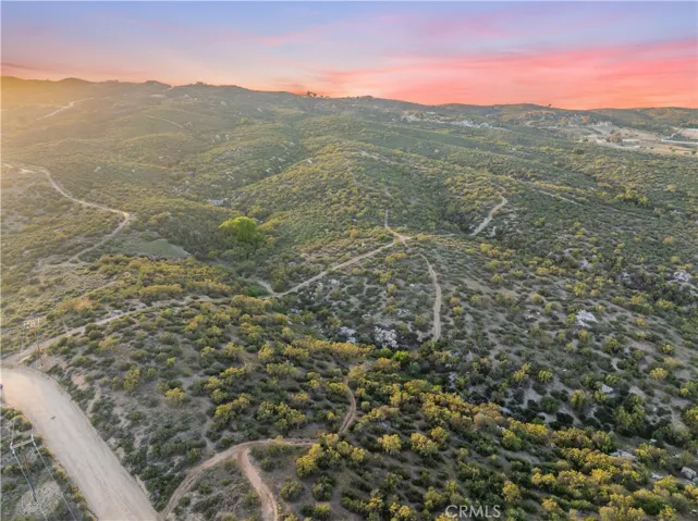 Aerial view, showcasing the property, rolling terrain, natural beauty, and expensive open space views.