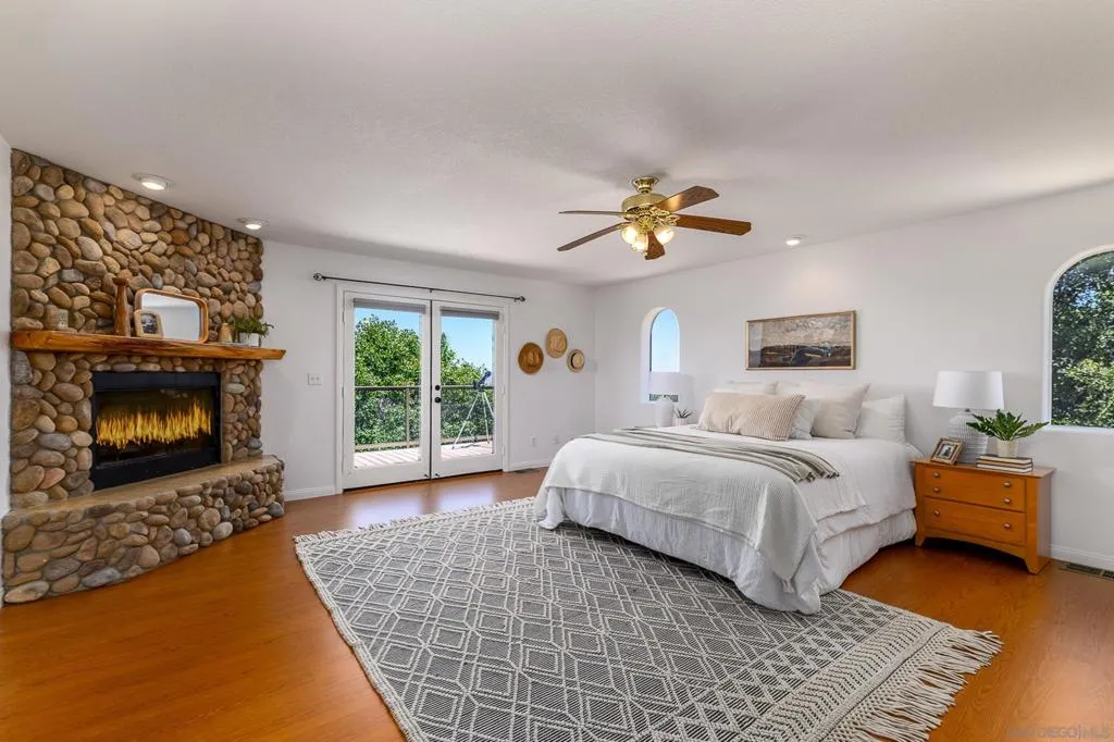 Primary Bedroom with wood burning fireplace and french doors to deck