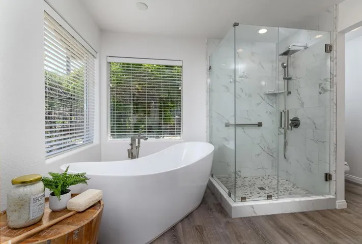 Primary Bathroom with Dual Vanities, soaking tub, walk-in shower, water closet and walk-in closet