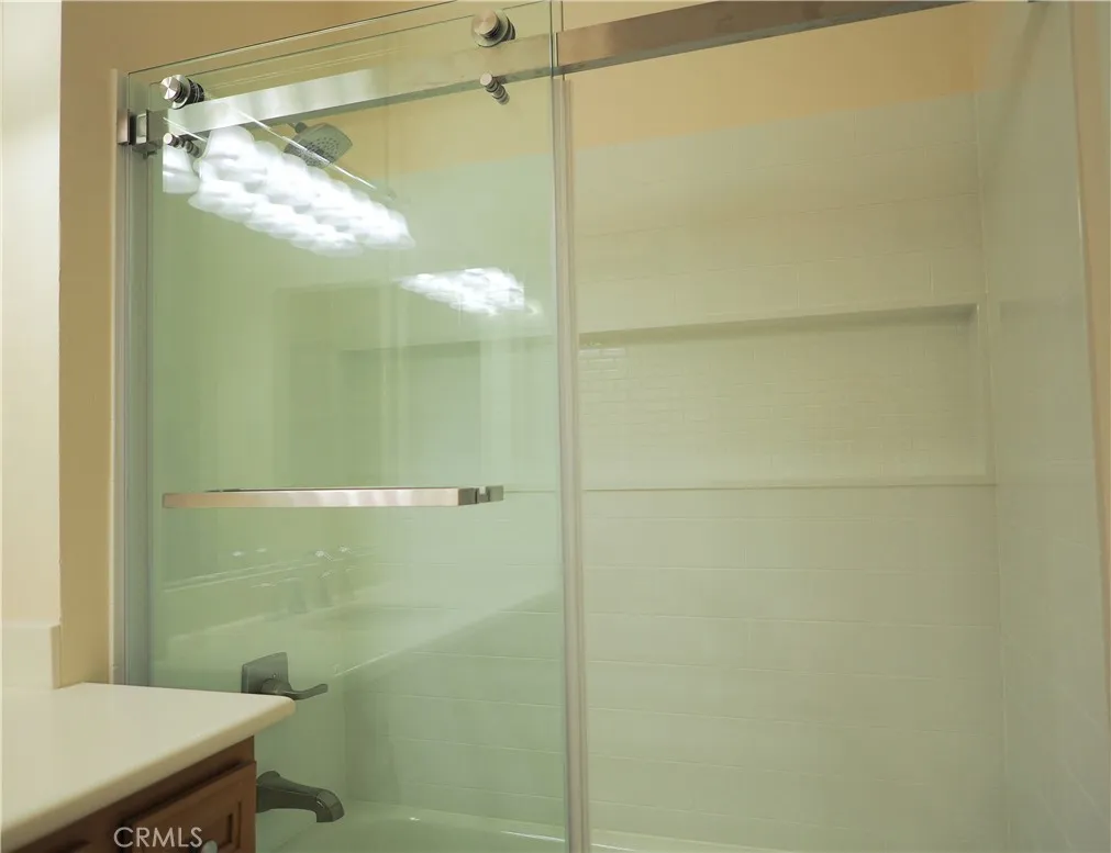 Primary bathroom with newer shower/tub enclosure and glass door
