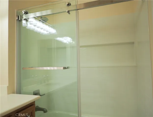 Primary bathroom with newer shower/tub enclosure and glass door