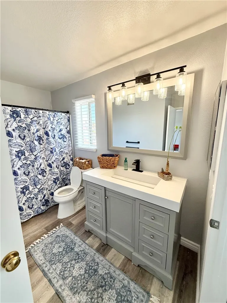 Upstairs Bathroom has a new vanity cabinet with cultured marble top with black sink faucet and black vanity 5 light bar.