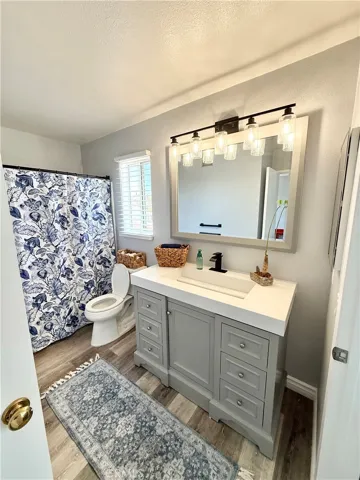 Upstairs Bathroom has a new vanity cabinet with cultured marble top with black sink faucet and black vanity 5 light bar.