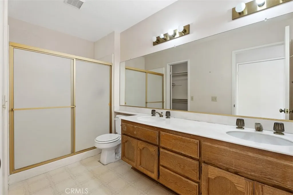 Spacious primary bathroom with dual sinks, walk in shower and large walk in closet.