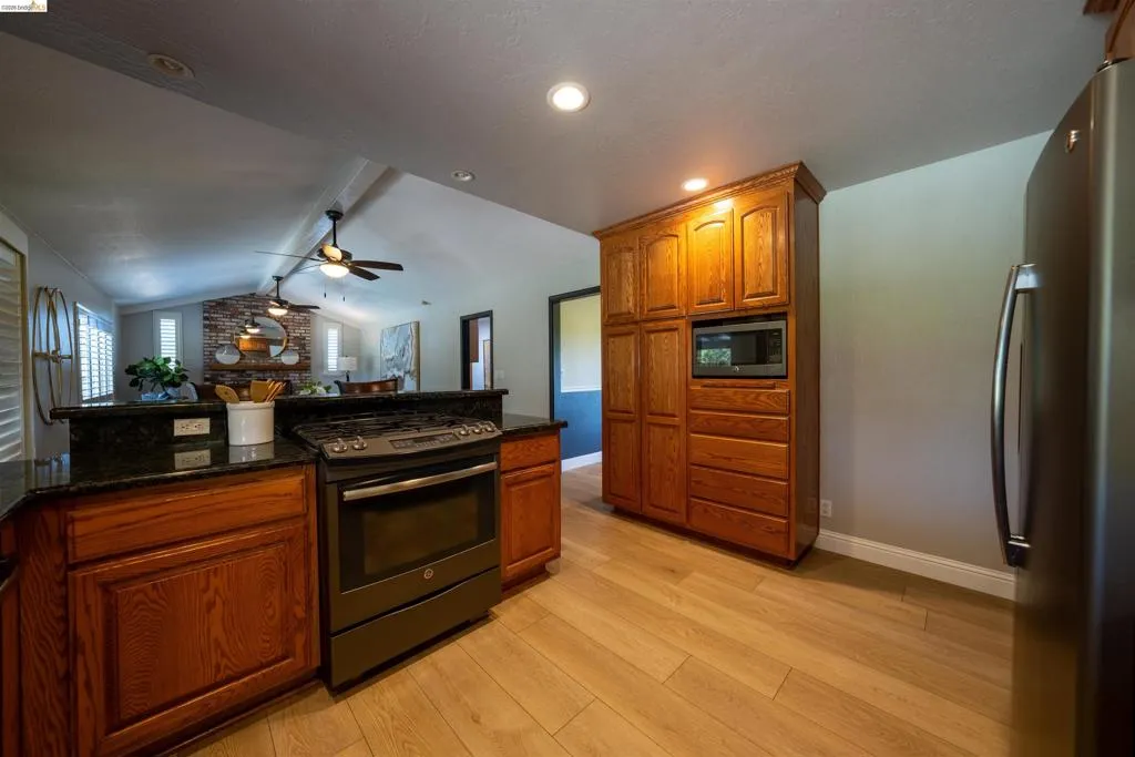 Kitchen featuring wood-finish flooring and rich wood cabinetry