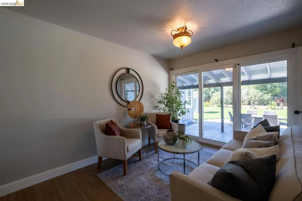 Sliding glass doors opening to an outdoor patio with concrete flooring
