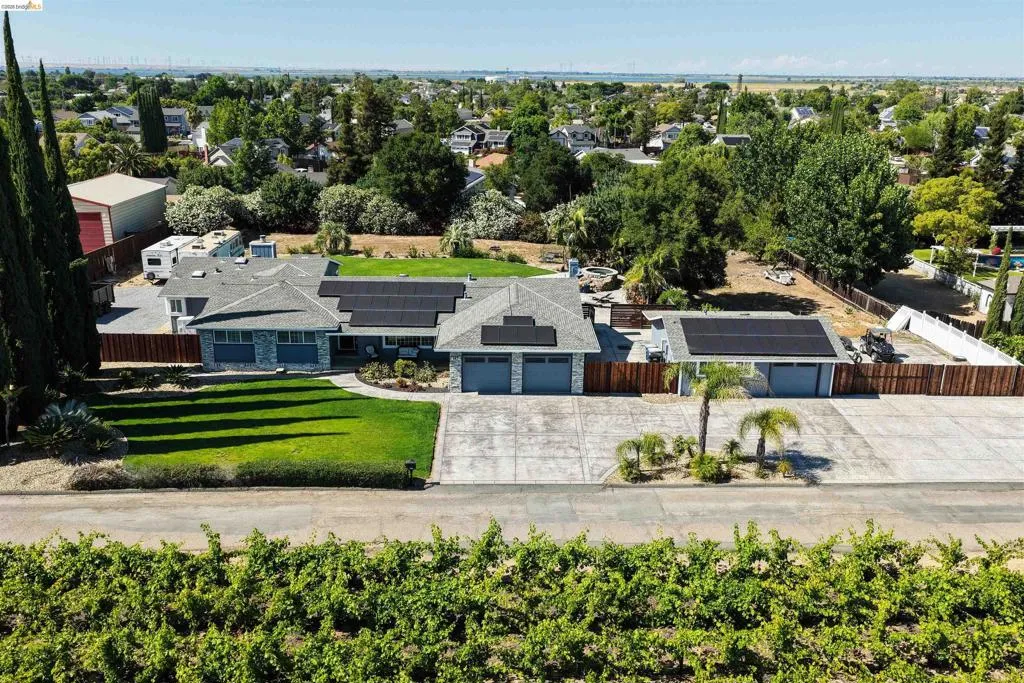 Stone veneer facade featuring a manicured front lawn and a concrete driveway