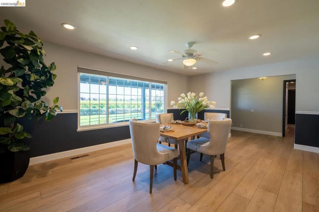 Dining area with wood-finish flooring, recessed lighting, and a ceiling fan