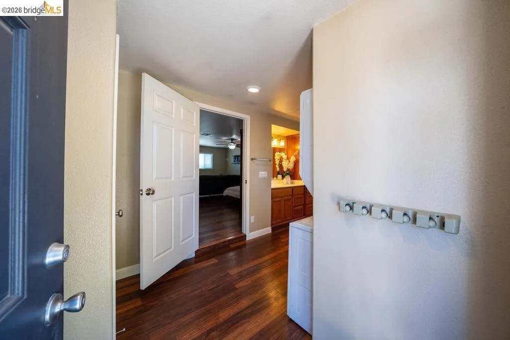 Entryway featuring wood-finish flooring, a six-panel interior door, and neutral wall tones