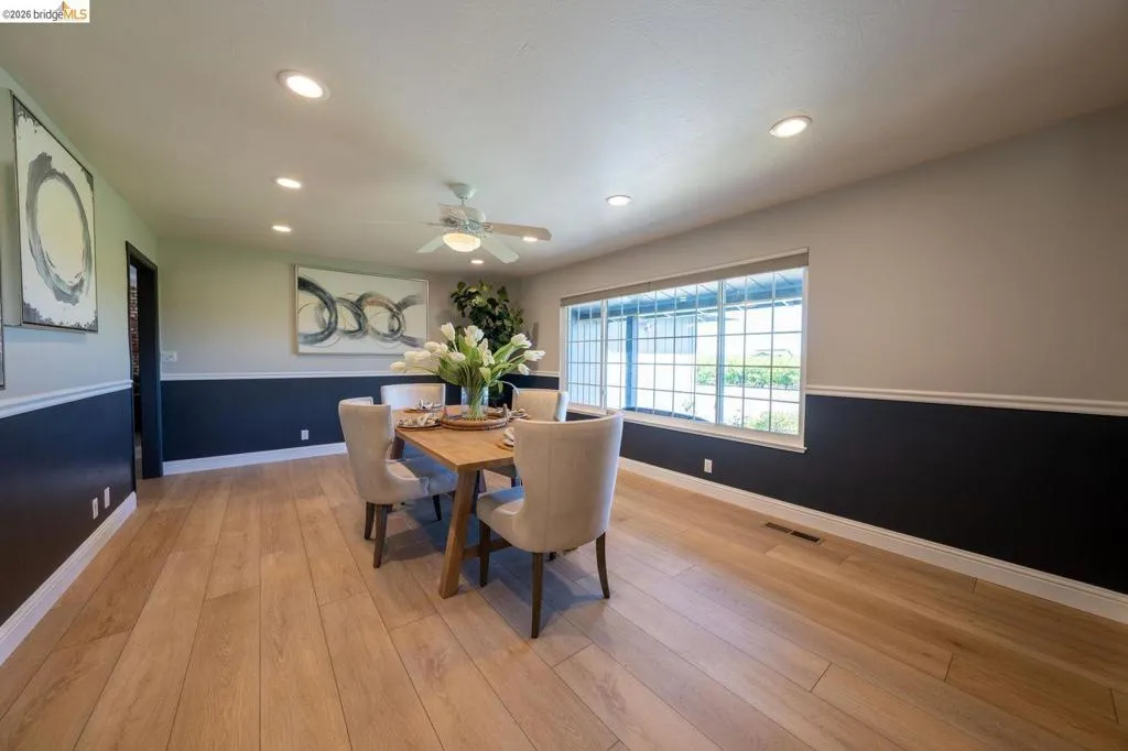 Open concept room featuring light wood-finish flooring, a contemporary ceiling fan, and recessed lighting
