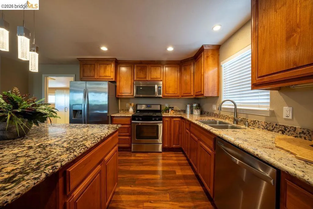Kitchen featuring wood-finish flooring, recessed lighting, and a dual-basin sink with a gooseneck faucet