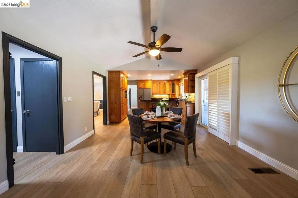 Open-concept living space featuring wood-finish flooring, a contemporary ceiling fan, and recessed lighting
