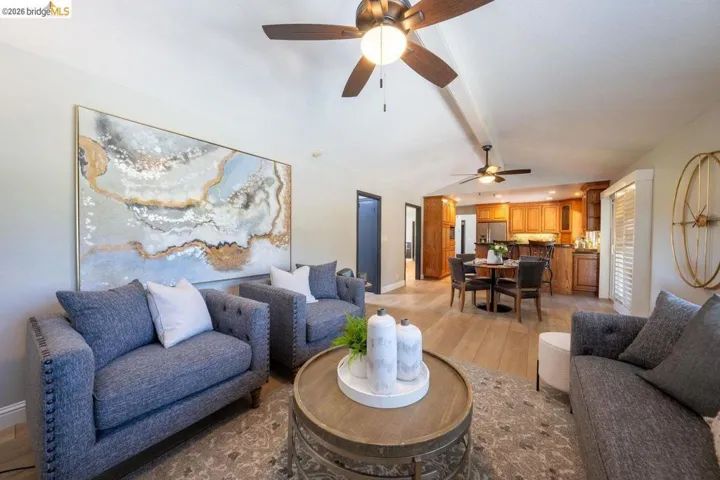 Open-concept living space featuring vaulted ceilings and wood-finish flooring