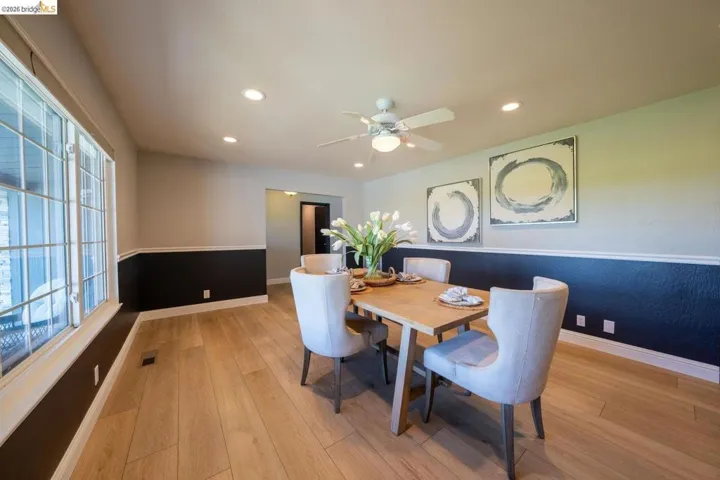 Dining area featuring light wood-finish flooring, a contemporary ceiling fan, recessed lighting, and a multi-pane window