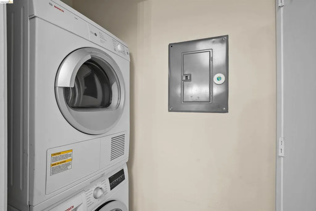Stacked laundry appliances with a front-loading dryer and a lower front-loading washer